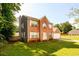 View of a two-story brick home with black siding and a well-maintained lawn and two-car garage at 3730 Warriors Path, Decatur, GA 30034