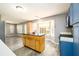 Open kitchen with a wooden island, stainless steel appliances, and bright natural light from the bay windows at 3730 Warriors Path, Decatur, GA 30034