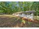 Exterior view of property with painted white brick and lush tree coverage at 5155 Oakdale Ct, Douglasville, GA 30135