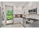 Modern kitchen with stainless steel appliances and white shaker cabinets with an access door to backyard deck at 571 Morgan Ne St, Atlanta, GA 30308