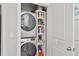 Convenient laundry room featuring a stacked washer and dryer, and built-in shelving for storage at 571 Morgan Ne St, Atlanta, GA 30308