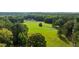 Picturesque aerial view of a sprawling green estate nestled among dense trees at 7255 Old Rico Rd, Chattahoochee Hills, GA 30268
