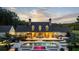 Expansive back exterior showcasing a pool, patio, and lush landscaping under a beautiful sunset sky at 7255 Old Rico Rd, Chattahoochee Hills, GA 30268