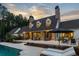 Backyard view of a stone-clad home with pool, lounge chairs, patio, and manicured landscaping at 7255 Old Rico Rd, Chattahoochee Hills, GA 30268
