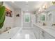 Spa-like bathroom with a soaking tub, double vanity, and elegant fixtures at 7255 Old Rico Rd, Chattahoochee Hills, GA 30268