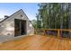 A wooden deck with seating offers seamless indoor-outdoor living and scenic backyard views at 7255 Old Rico Rd, Chattahoochee Hills, GA 30268