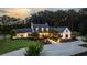 Stunning country home featuring manicured landscaping and a circular driveway at sunset at 7255 Old Rico Rd, Chattahoochee Hills, GA 30268
