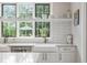 Sunlit kitchen featuring white cabinets, subway tile backsplash, and open shelving at 7255 Old Rico Rd, Chattahoochee Hills, GA 30268