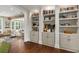 Open-concept living area featuring built-in shelving and cabinets, hardwood floors, and natural light at 7255 Old Rico Rd, Chattahoochee Hills, GA 30268