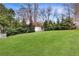 Expansive backyard featuring a lush green lawn, privacy trees, and a charming white picket fence at 1466 University Dr, Atlanta, GA 30306