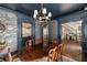 Elegant dining room with dark blue walls, traditional wooden table and chairs, and grand staircase at 1466 University Dr, Atlanta, GA 30306