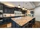 Charming kitchen boasting an expansive island with seating, granite counters, and stylish dark cabinetry at 1466 University Dr, Atlanta, GA 30306