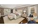 A spacious main bedroom features an oversized bed, white linens, hardwood floors, and natural light at 1466 University Dr, Atlanta, GA 30306