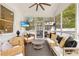 Screened-in porch with wicker furniture, ceiling fan, and a mounted television for outdoor entertainment at 1466 University Dr, Atlanta, GA 30306