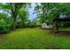 Large grassy backyard featuring a storage shed and a covered swing set area at 218 Woodview Se Ln, Smyrna, GA 30082