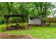Backyard featuring a swing set, shed, and green landscaping at 218 Woodview Se Ln, Smyrna, GA 30082