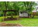 View of backyard with shed and covered swing area and lots of green space at 218 Woodview Se Ln, Smyrna, GA 30082