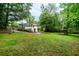 Sprawling green backyard featuring mature trees, a swing set, and a covered shelter at 218 Woodview Se Ln, Smyrna, GA 30082