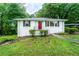 Charming single-story home with a red front door, white brick, and lush landscaping at 218 Woodview Se Ln, Smyrna, GA 30082