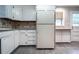 Clean kitchen featuring white cabinets, appliances, and a window view at 218 Woodview Se Ln, Smyrna, GA 30082