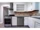 This kitchen features stainless steel appliances, white cabinets and a tile backsplash at 218 Woodview Se Ln, Smyrna, GA 30082