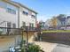 View of townhome with a charming wooden deck and ground level garage perfect for storage at 2450 Mildon Hall Ln, Lawrenceville, GA 30043