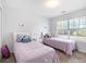 Bright bedroom featuring two beds, a window, and neutral walls at 2450 Mildon Hall Ln, Lawrenceville, GA 30043