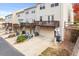 Rear exterior view of multi-level townhomes, each featuring a garage, private decks, and manicured landscaping at 2450 Mildon Hall Ln, Lawrenceville, GA 30043