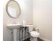 Powder room with pedestal sink, round mirror, and neutral tones, creating a fresh and clean space at 103 Prominence Ct, Canton, GA 30114