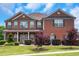 Beautiful two-story brick home featuring a covered front porch and manicured landscaping at 1104 Stepping Stone Ln, Conyers, GA 30012