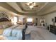 Spacious main bedroom featuring a tray ceiling, decorative lighting, and an additional sitting area at 1104 Stepping Stone Ln, Conyers, GA 30012