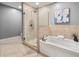 Bathroom featuring a glass-enclosed shower, a soaking tub, and tile flooring at 905 Ju Ne Street Ne St, Atlanta, GA 30309