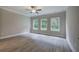 Bright bedroom featuring hardwood floors, three windows, and a ceiling fan at 109 Sunflower Ne Cir, Cartersville, GA 30121