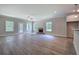 Living room view with stone fireplace, grey wood floors, a ceiling fan, and ample windows at 109 Sunflower Ne Cir, Cartersville, GA 30121