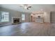 Open-concept living area showcasing a stone fireplace, modern ceiling fan, wood floors, and adjacent kitchen at 109 Sunflower Ne Cir, Cartersville, GA 30121