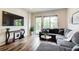 Inviting living room with hardwood floors, a comfortable sectional sofa, and access to a balcony with outdoor views at 1418 Dresden Ne Dr # 385, Brookhaven, GA 30319