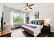 Bright main bedroom boasts a ceiling fan, large window, and a comfortable king bed with nice wood flooring at 1418 Dresden Ne Dr # 385, Brookhaven, GA 30319