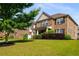 Beautifully landscaped front yard showcasing a two-story brick home with a covered porch at 1520 Gallant Fox Ln, Suwanee, GA 30024