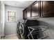 Modern laundry room featuring dark cabinets, a window, and high-efficiency washer and dryer set at 1520 Gallant Fox Ln, Suwanee, GA 30024