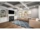 Cozy living room featuring a fireplace, built-in bookshelves, and large windows at 1520 Gallant Fox Ln, Suwanee, GA 30024