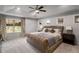 Main bedroom features a trey ceiling, ceiling fan, carpet flooring, and a large bed at 1520 Gallant Fox Ln, Suwanee, GA 30024