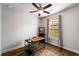 Well-lit office space with a ceiling fan, hardwood floors, a window, and a stylish black and brown desk at 1520 Gallant Fox Ln, Suwanee, GA 30024