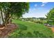Expansive backyard with lush lawn and mature trees, offering a private outdoor space with scenic lake views at 2045 Calmwater Ct, Suwanee, GA 30024
