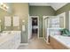 Bathroom featuring double sinks, walk-in closet, large soaking tub, and a glass shower at 2045 Calmwater Ct, Suwanee, GA 30024