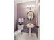 Powder room featuring a pedestal sink, round mirror, and decorative three-bulb light fixture at 2045 Calmwater Ct, Suwanee, GA 30024