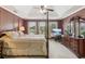 Bedroom with four-poster bed, lake view, tray ceiling, and neutral colored carpet at 2045 Calmwater Ct, Suwanee, GA 30024