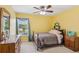 Bright bedroom features a ceiling fan and window overlooking the outdoor landscape at 2045 Calmwater Ct, Suwanee, GA 30024