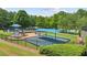 Community playground features swings and slides with mature trees and green space at 2045 Calmwater Ct, Suwanee, GA 30024