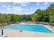 Beautiful swimming pool with abundant lounge chairs surrounded by mature trees at 2045 Calmwater Ct, Suwanee, GA 30024