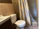 Bathroom featuring a sink, toilet, and shower with yellow-and-gray patterned curtain at 2226 Medfield Ne Trl, Atlanta, GA 30345